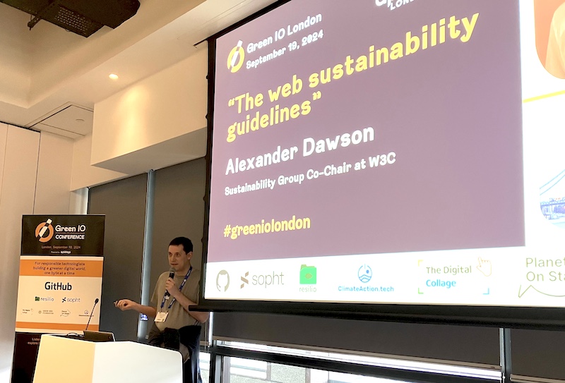 Alexander Dawson on stage behind the lectern. The title slide says “The web sustainability guidelines”