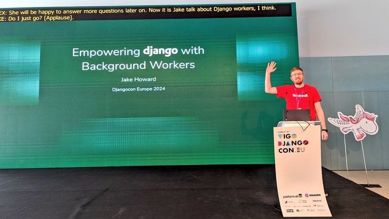 Jake on stage, waving, his slide reads "Empowering django with background workers", Jake Howard, DjangoCon Europe 2024