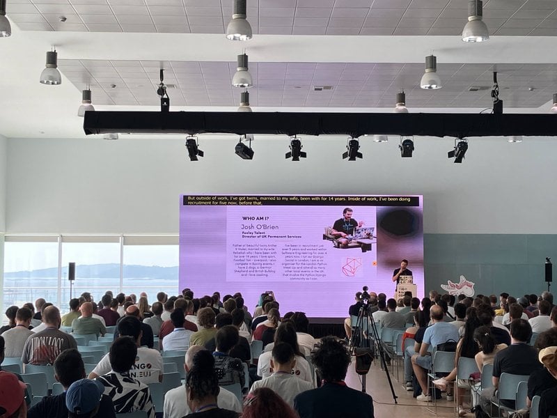 Josh O'Brien on stage, with the sea in the background