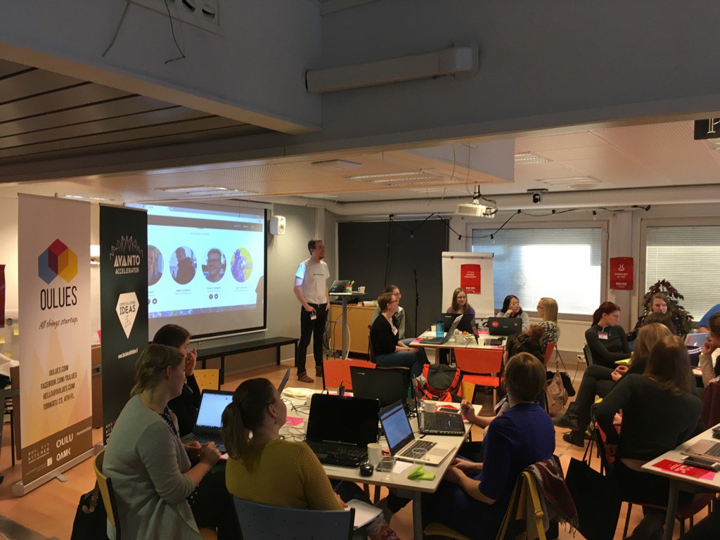 Picture of the room, Dan presenting, the audience sitting around work tables